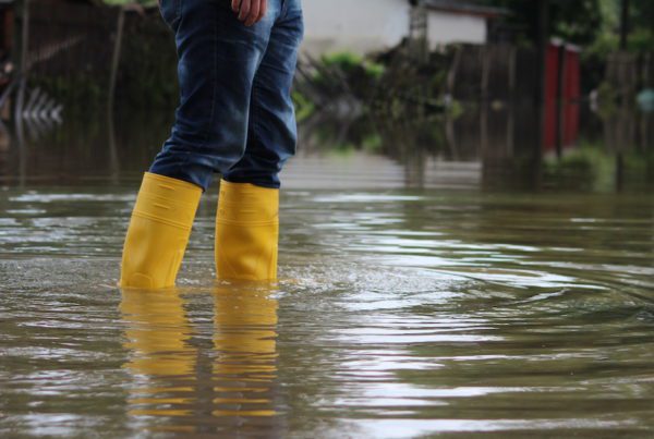 Blog - Person-Standing-In-High-Water-Wearing-Yellow-Rain-Boots-And-Jeans
